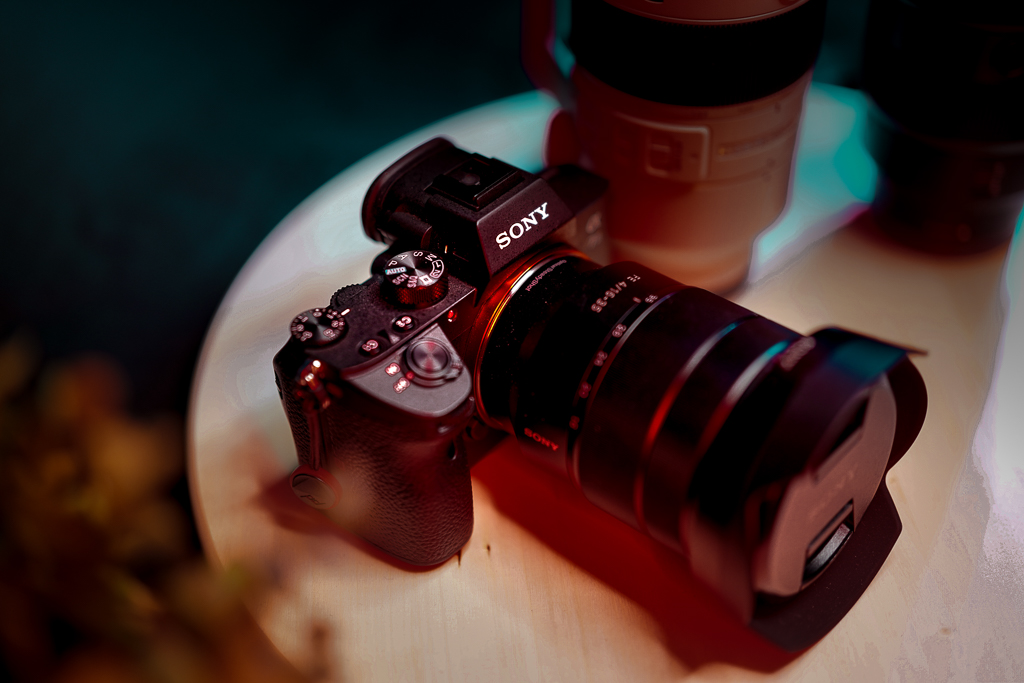 Sony mirrorless camera with attached zoom lens placed on a wooden table.