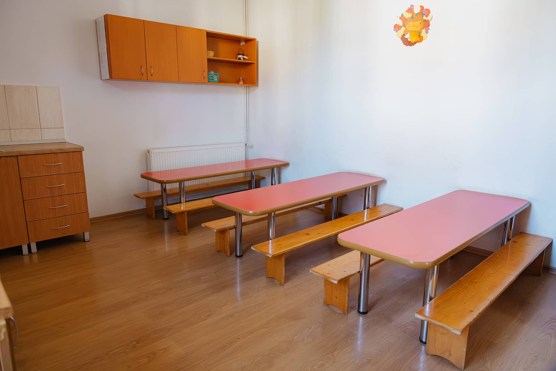 Az óvoda egyik étkezője gyerekeknek kialakított alacsony asztalokkal és padokkal.