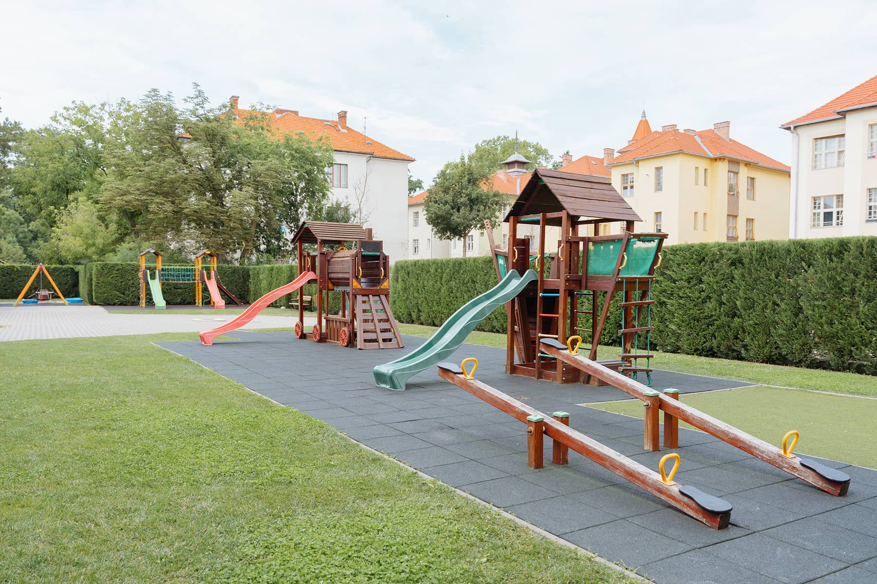 Az óvoda udvara, modern játszótérrel, csúszdákkal, mászókákkal és libikókákkal.