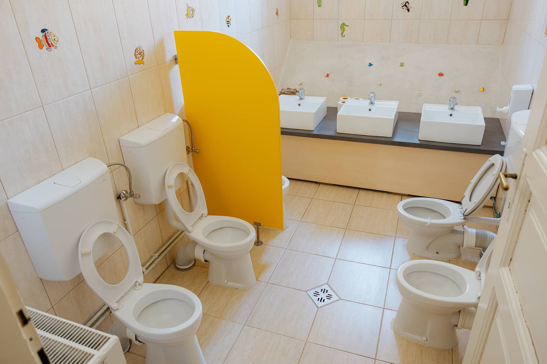 Gyermekmosdó óvodai WC-kkel és alacsony mosdókkal.