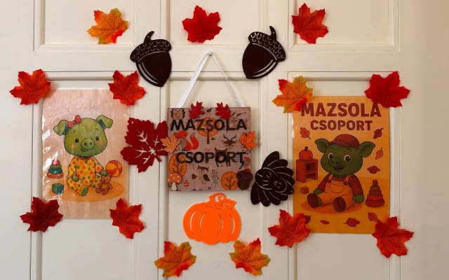 Mazsola csoport ajtódísz őszi levelekkel, makkokkal és Mazsola figurájával díszítve fehér ajtón