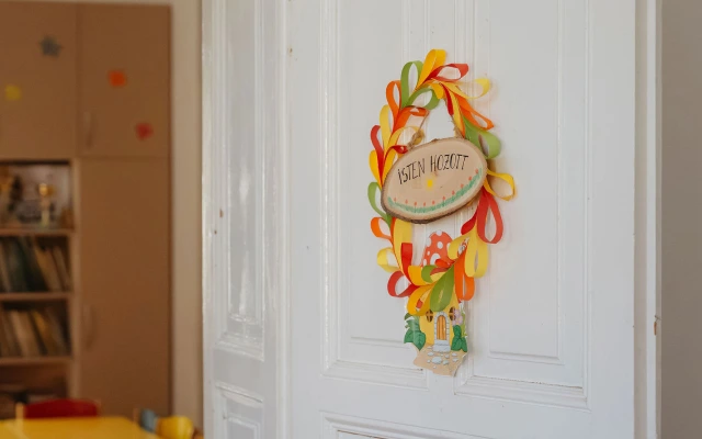 Az Angyalka csoport ajtaján egy színes, virágdíszes tábla Isten hozott felirattal.