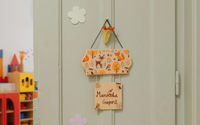 Manócska csoport ajtódísz erdei állatokkal és őszi mintákkal díszítve, világos ajtón elhelyezve