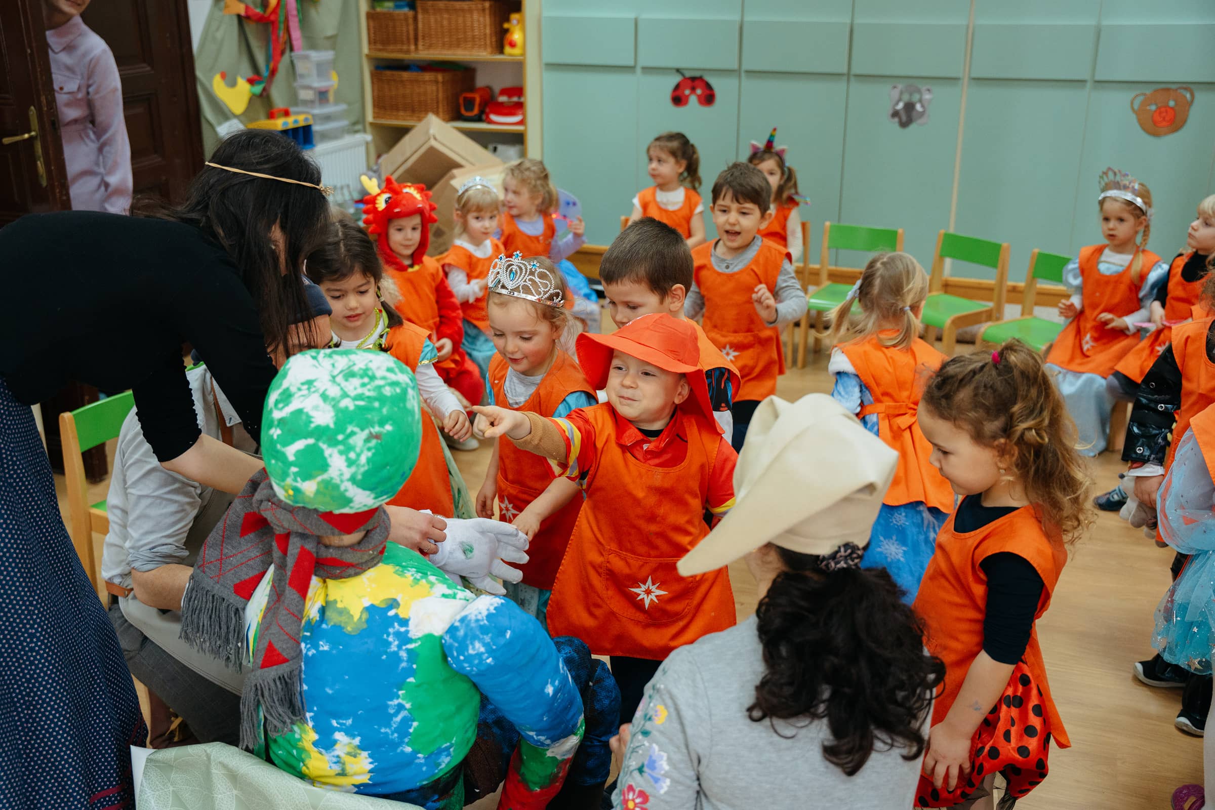 Copiii de grădiniță, îmbrăcați în costume, fac cunoștință cu păpușa de alungare a iernii.