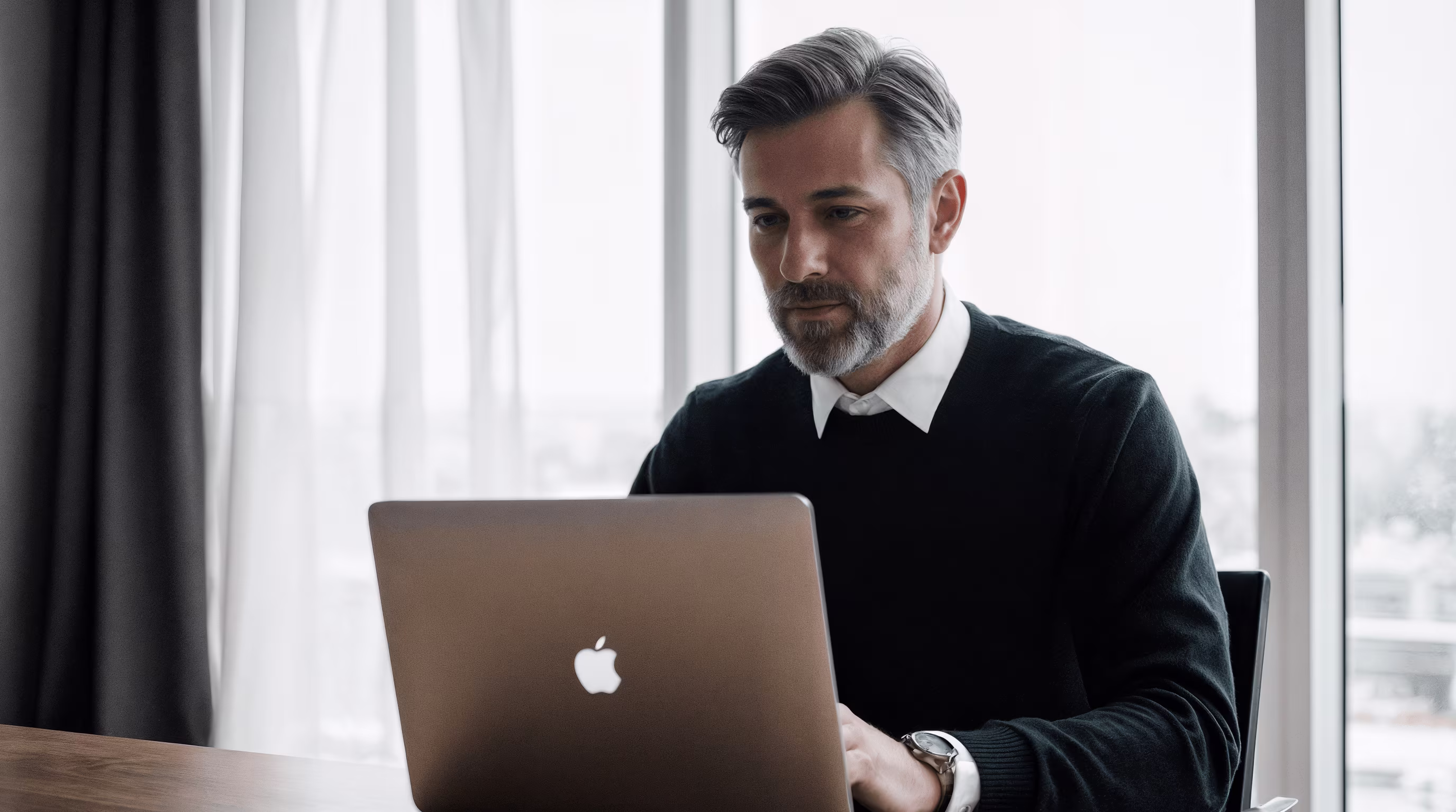 Homme professionnel discutant avec un collègue dans un open space moderne, MacBook Pro devant lui