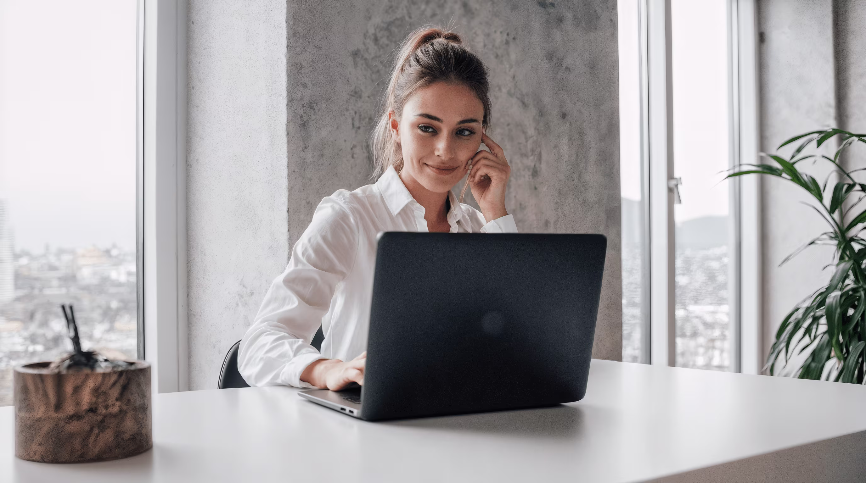 Femme professionnelle concentrée devant un MacBook, face au lac Léman, ambiance naturelle et calme