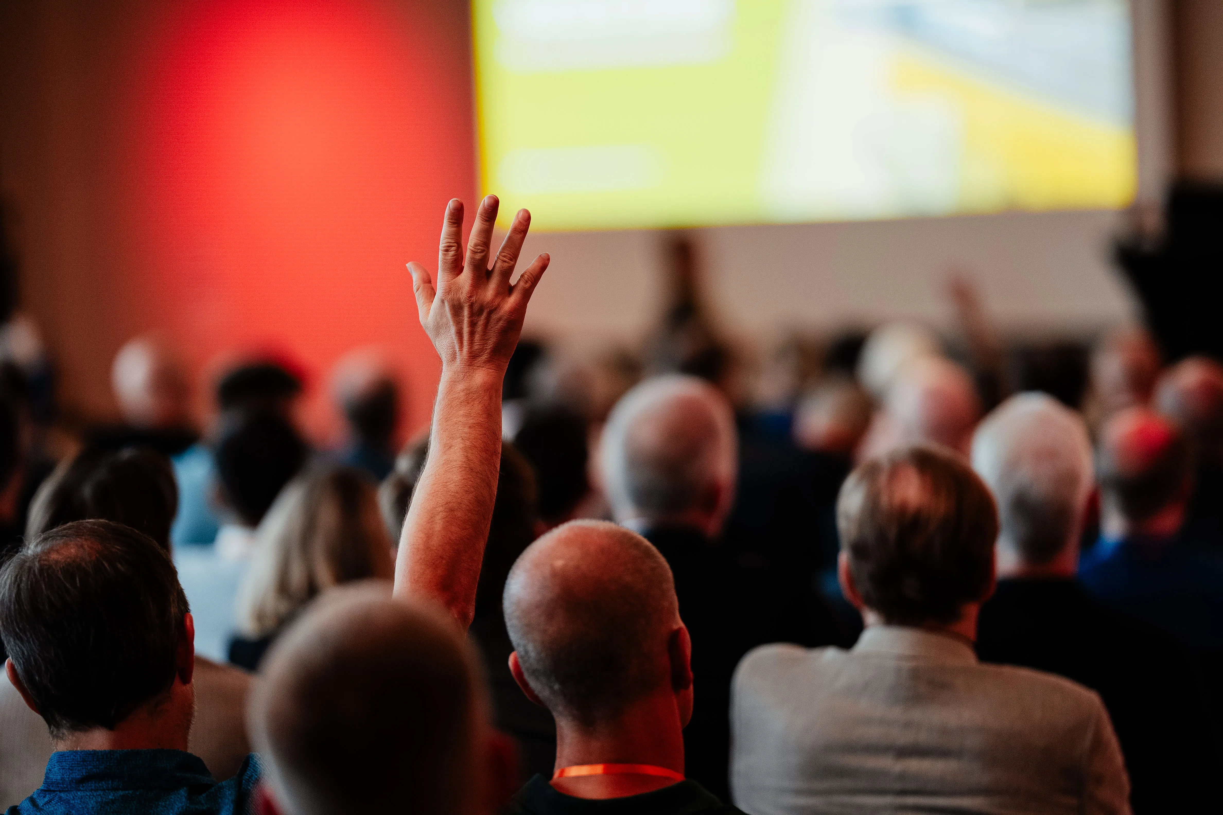 Publikum beim NexAI KI-Stammtisch im Speicher 10 Münster, eine Hand meldet sich zur Frage