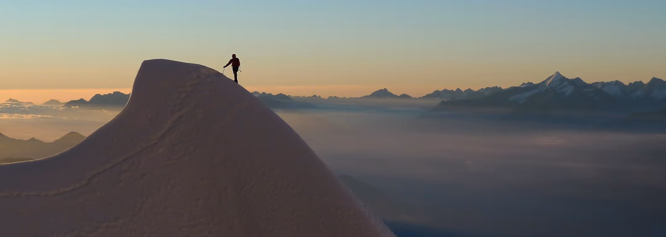Main hero - Mountaineer on mountain ridge with mountain guide