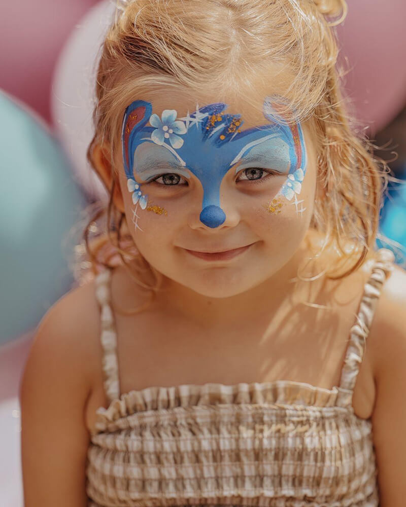 Een foto van een meisje met een Stitch gezicht geschminkt.