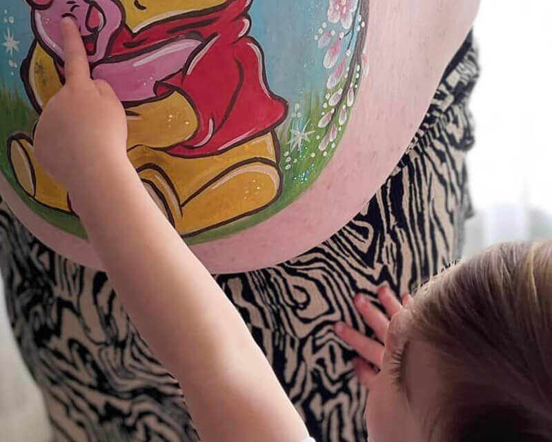 Een foto van een meisje dat de bellypaint aanwijst.