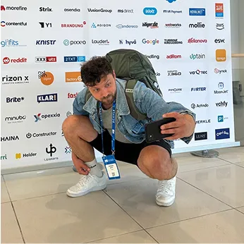 Teilnehmer einer Digitalmesse mit Phaina-Branding im Hintergrund.