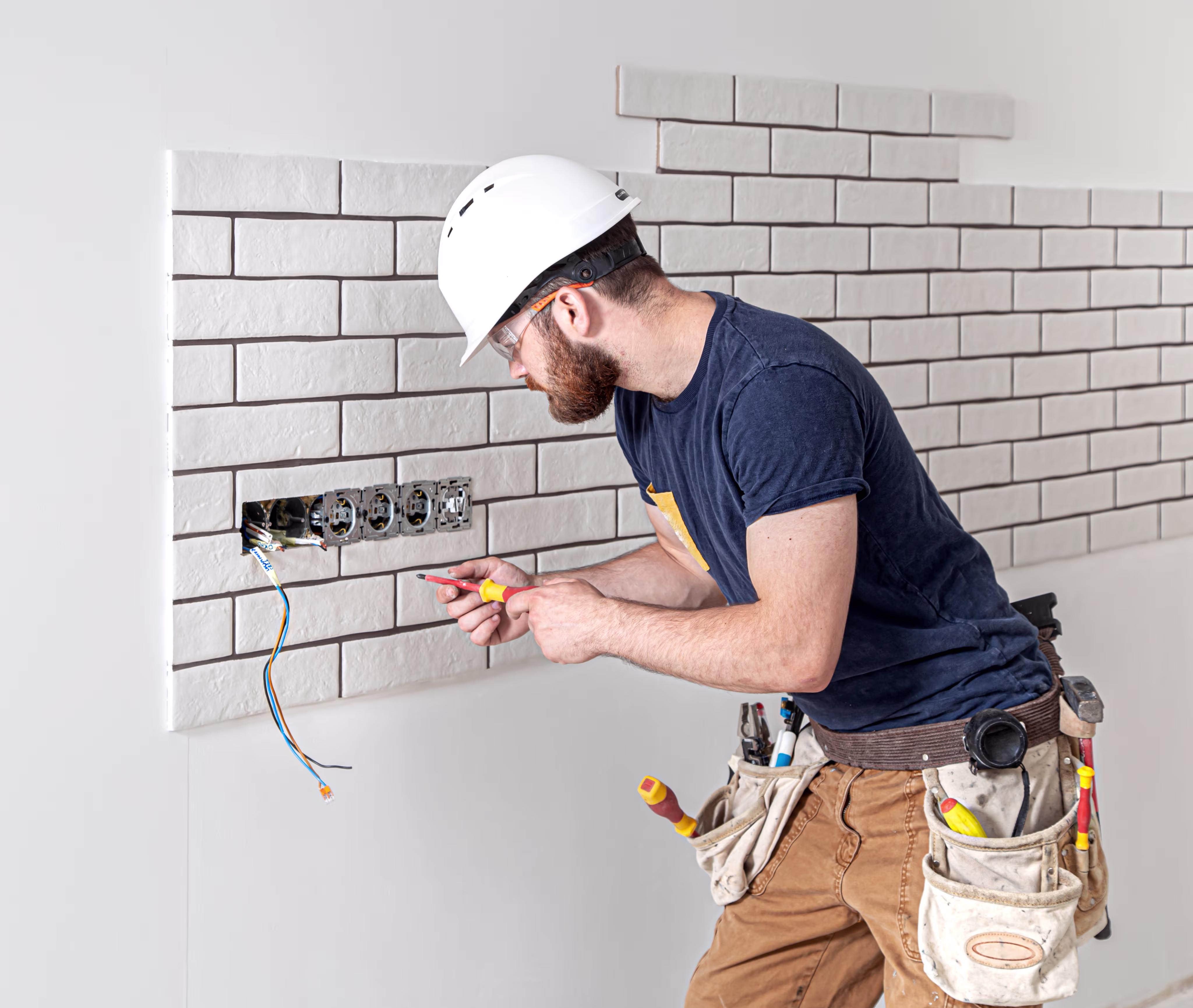 A man in a hard hat working on a wall.