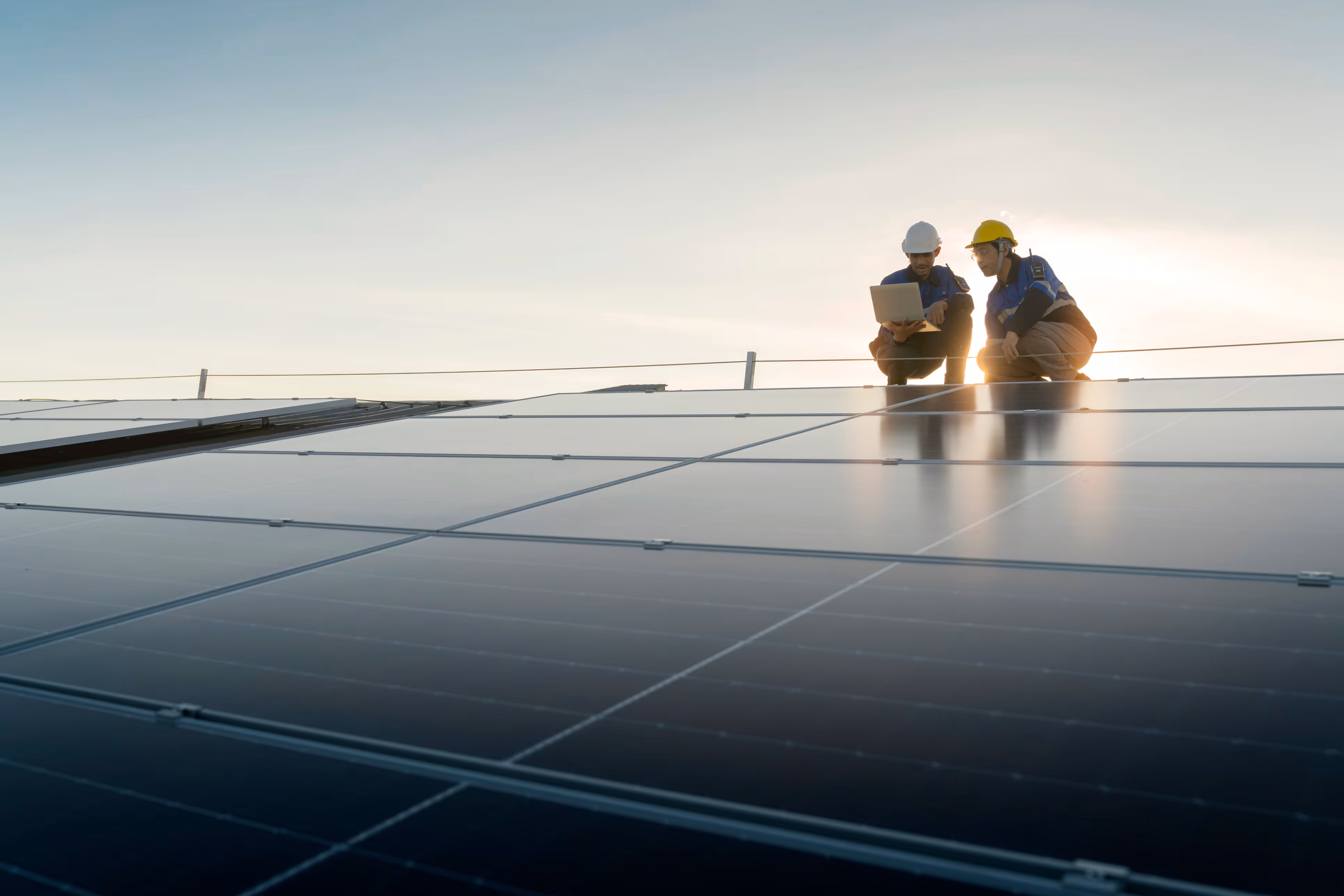 Two workers are sitting on the roof of a building.