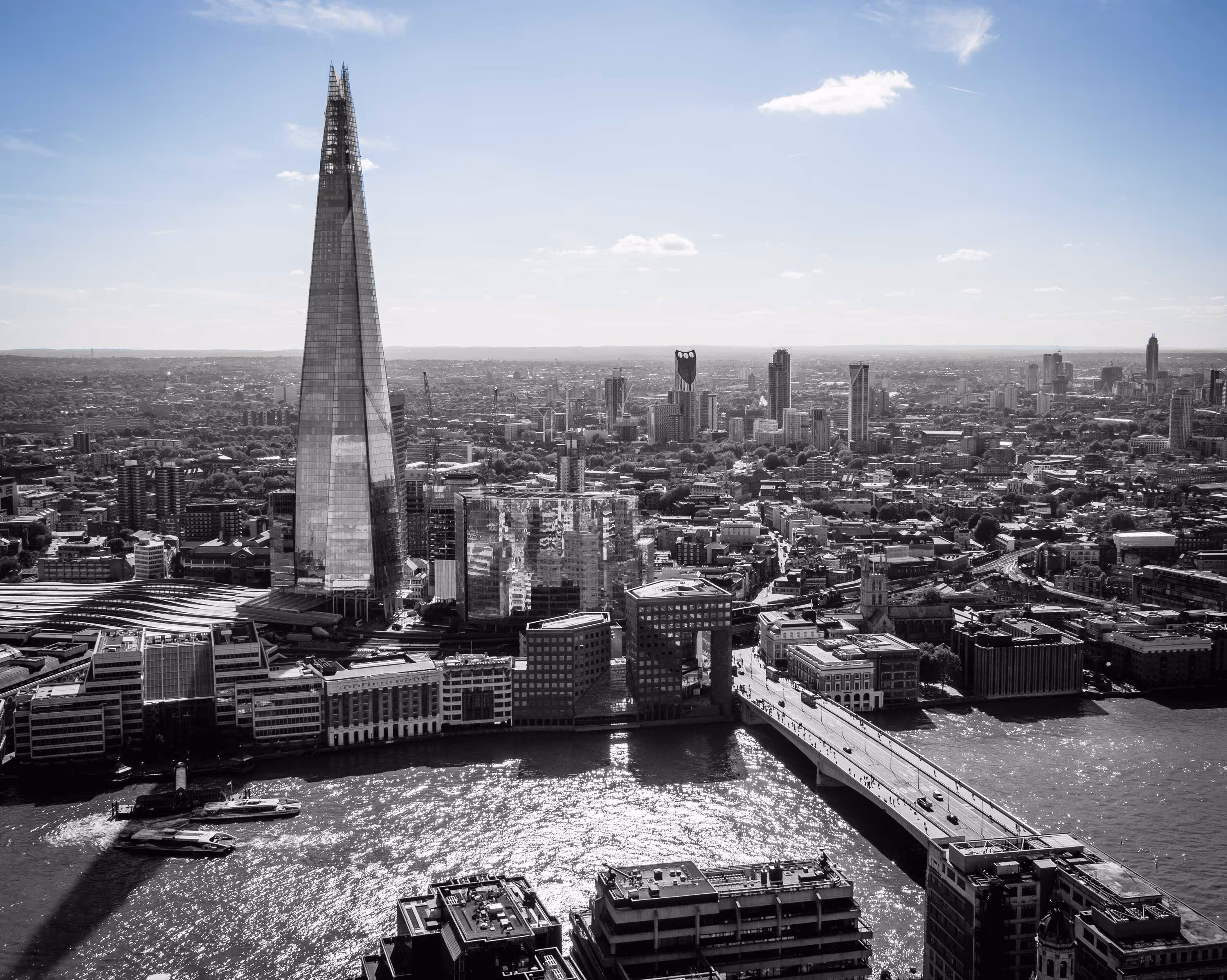 Aerial view of London featuring the Shard skyscraper and the River Thames on a clear day.