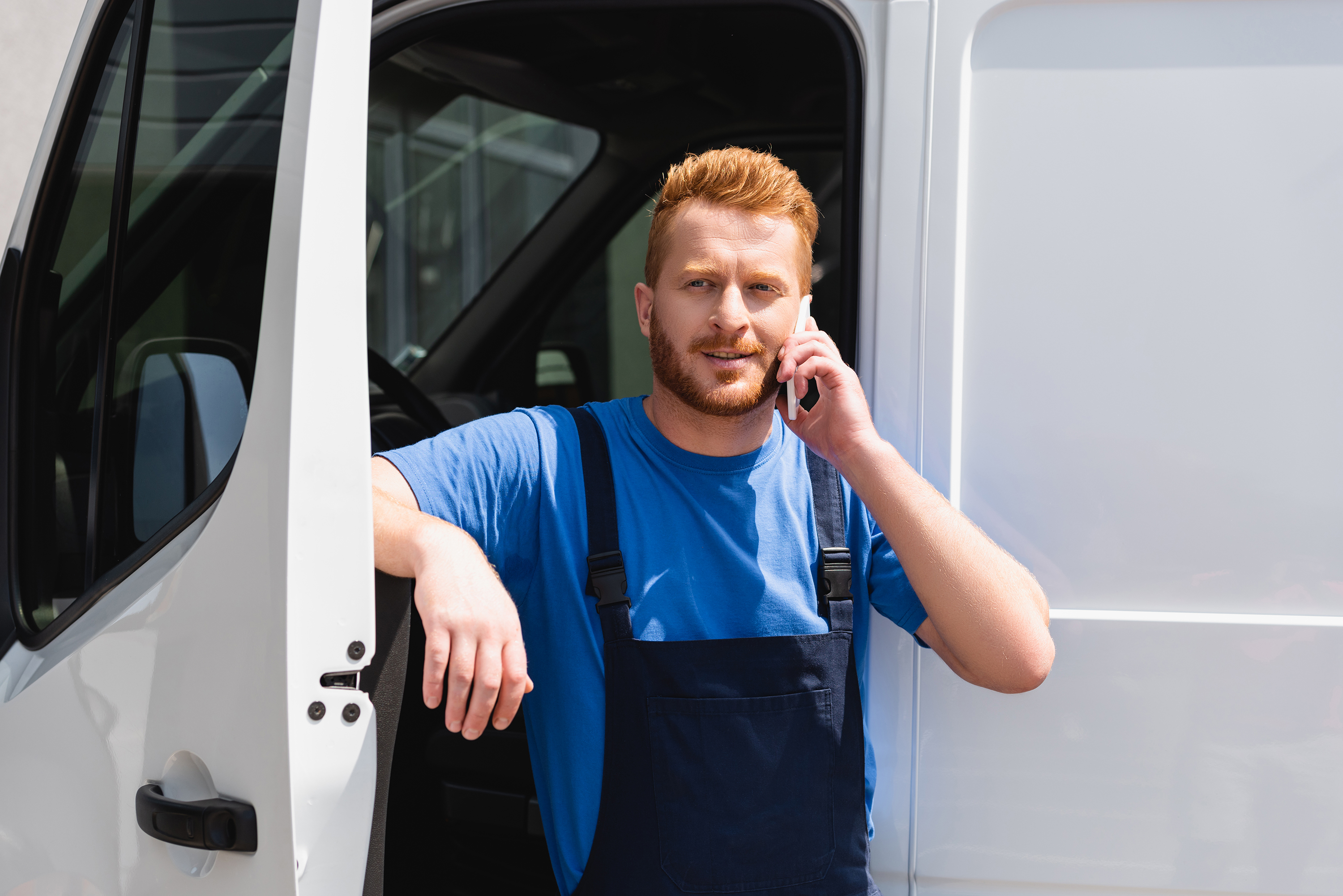 Service technician on cell phone by van