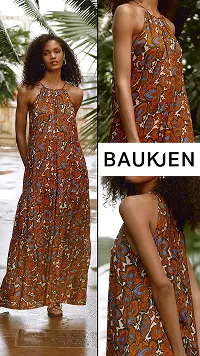 Woman wearing an orange, blue, and white patterned sleeveless maxi dress standing outdoors with green foliage background, showing front, side, and back views.