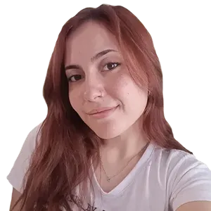 Young woman with long reddish hair wearing a white t-shirt and a necklace, smiling slightly.