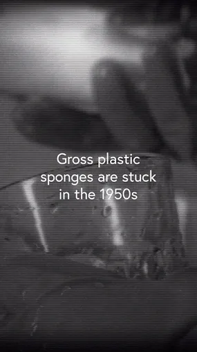 Black-and-white close-up image showing hands holding a plastic sponge with the text 'Gross plastic sponges are stuck in the 1950s' overlaid.