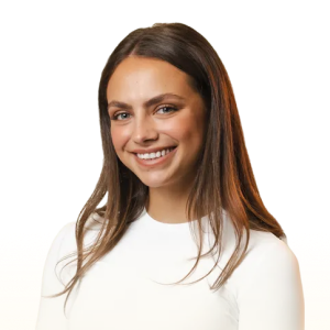 Smiling young woman with long brown hair wearing a white top on a transparent background.