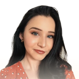 Portrait of a woman with long dark hair wearing a red polka dot blouse and small earrings.