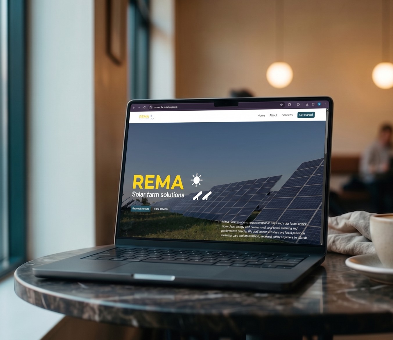Laptop on a marble table displaying REMA Solar Farm Solutions website with solar panels and navigation menu.
