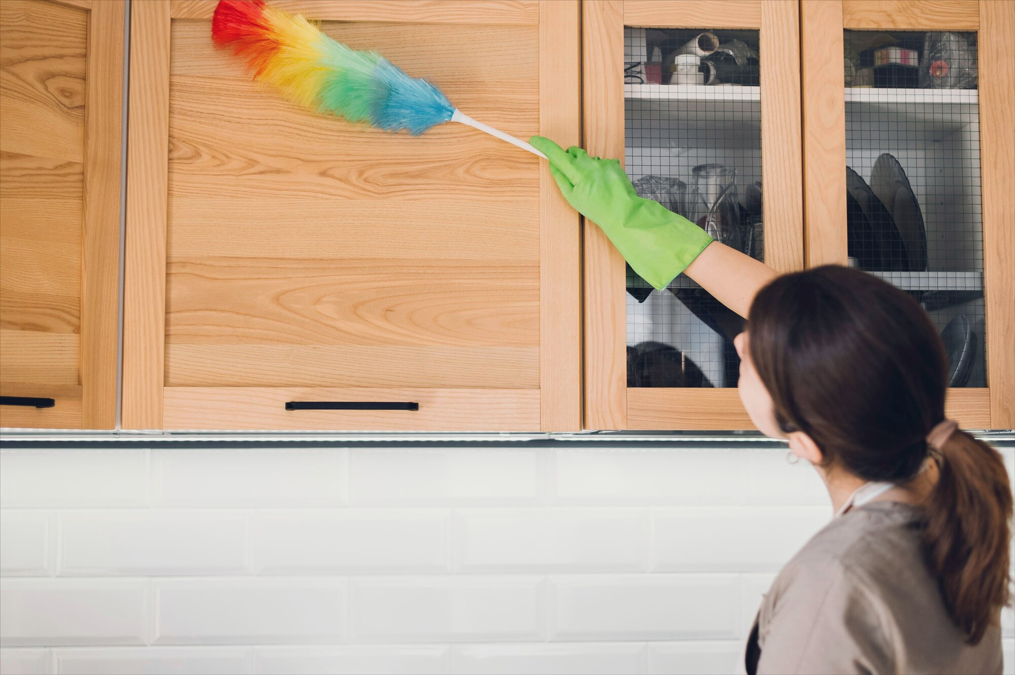 A Mary & A Mop expert demonstrating proper surface preservation techniques by dry-brushing cabinetry to prevent micro-scratches during a deep cleaning reset in Orange County.