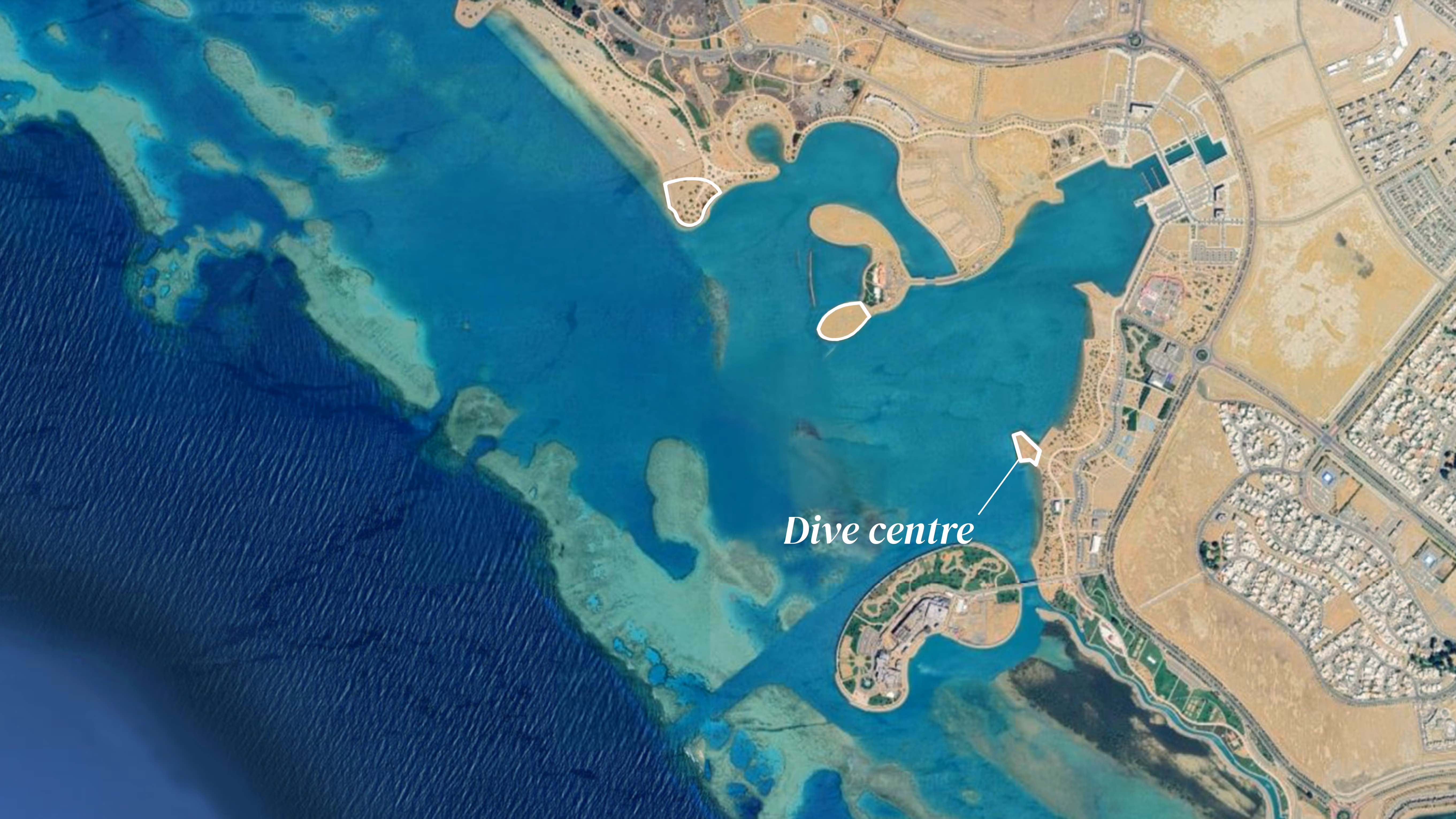 Aerial view of Yanbu, with clear blue water, coral reefs, a peninsula, and labeled the location of the Wellness Centre