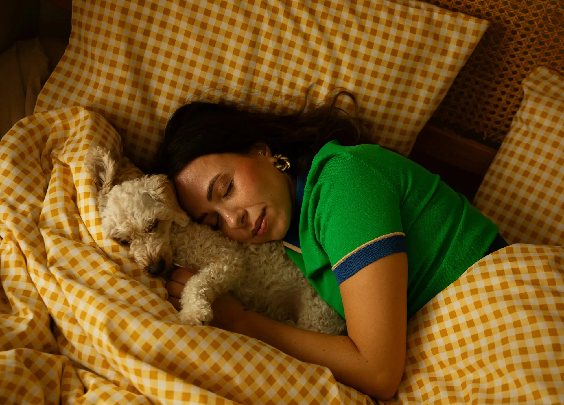 Woman resting comfortably in bed with her dog, representing calm and restorative sleep.
