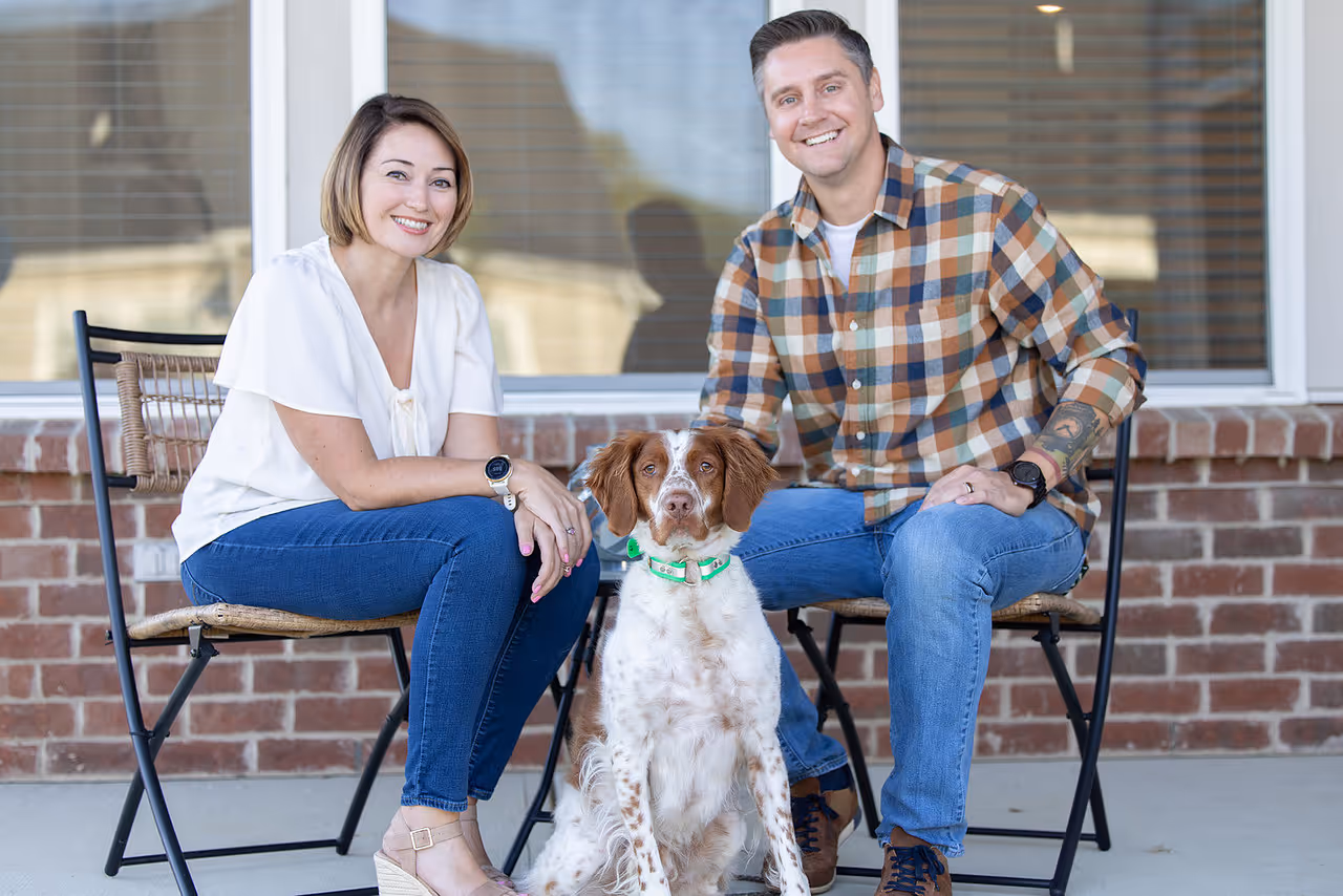 Racheal Bleicher sitting outside with her husband and dog