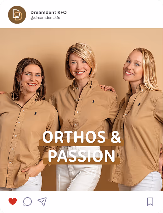 Drei Frauen des Dreamdent KFO Teams stehen vor einem beigefarbenen Hintergrund, tragen beige Teamhemden und lächeln in die Kamera. In der Bildmitte steht der Text ‚ORTHOS & PASSION‘.