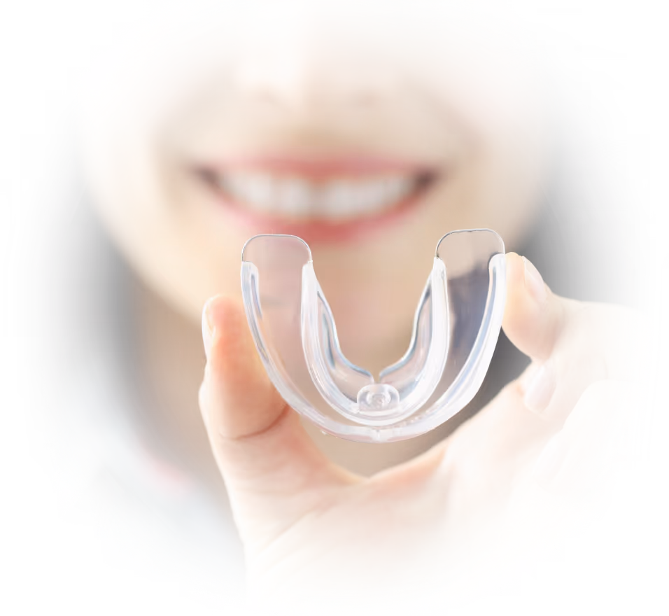 Frau hält eine transparente Zahnschiene in der Hand – moderne kieferorthopädische Aligner-Behandlung.