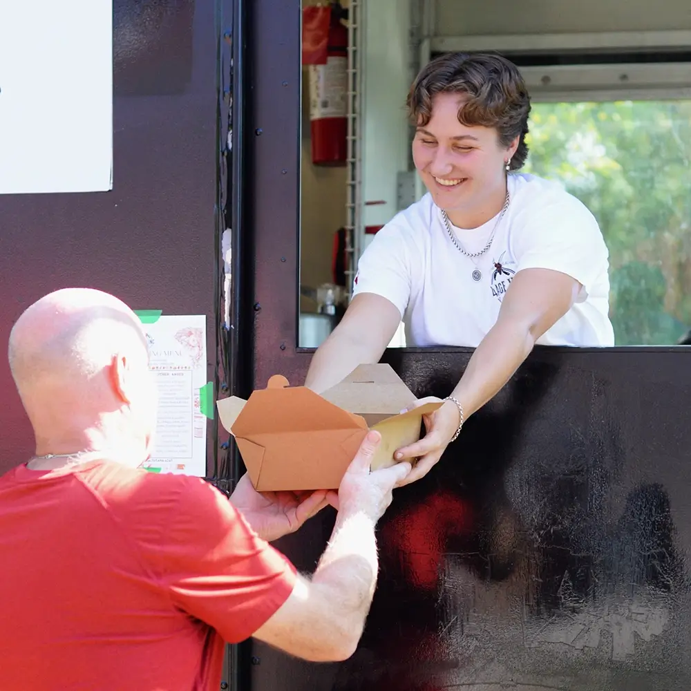 A customer getting his food from the food truck