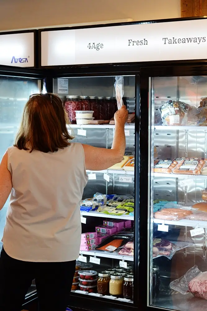 A woman at the 4age takeaway freezers.