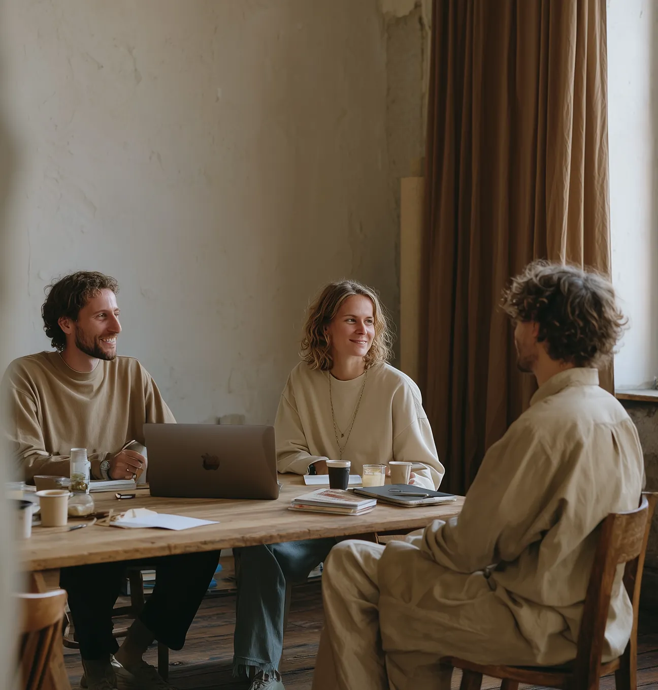 A team of three architects discussing design plans, illustrating collaboration and expert project planning in modern architecture.
