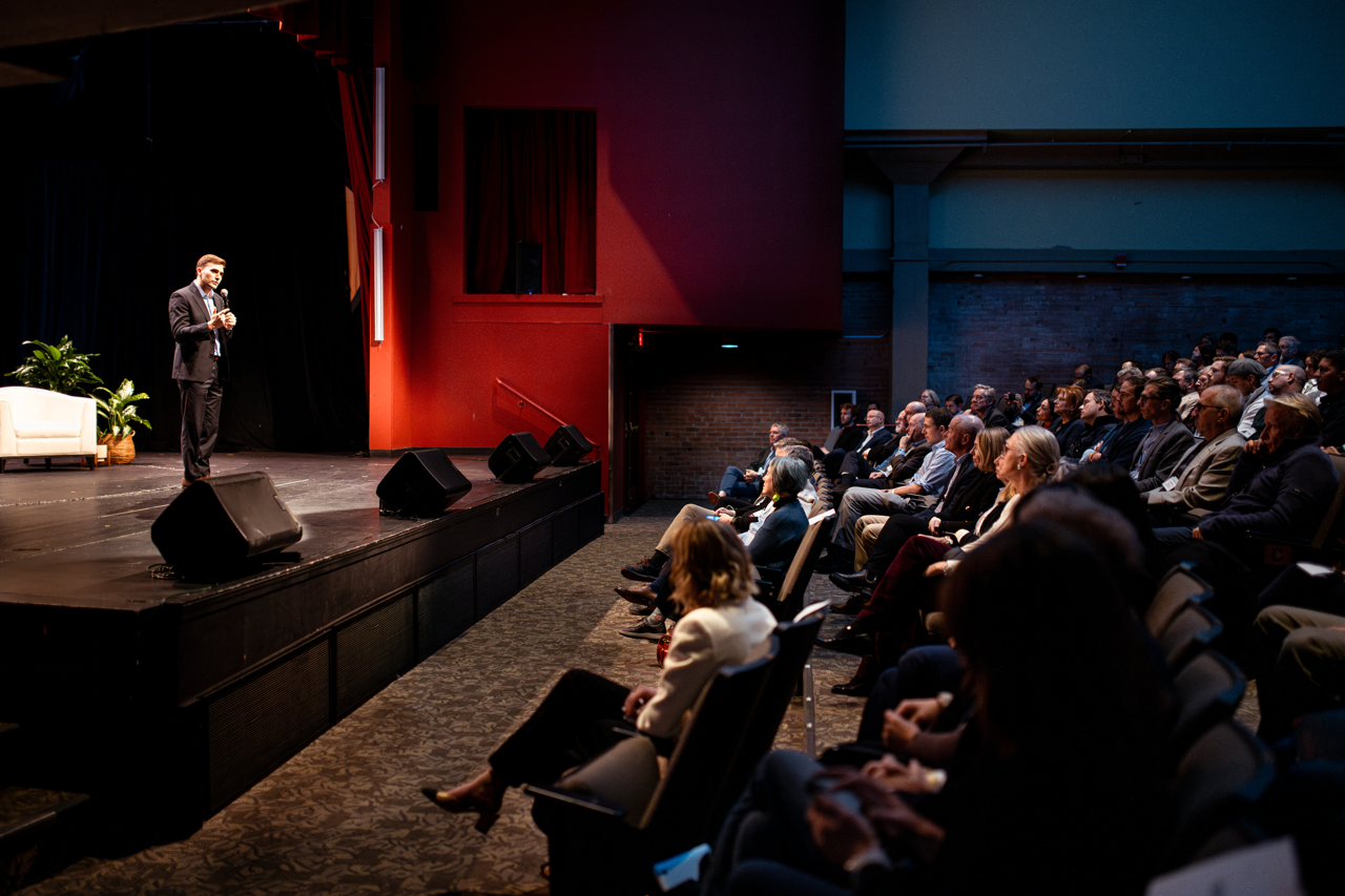 Adam Hammer speaks at the Roadrunner Tech Forum in 2024 to a full auditorium.