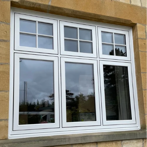 White UPVC window with three larger panes below and six smaller panes above set in a stone wall.