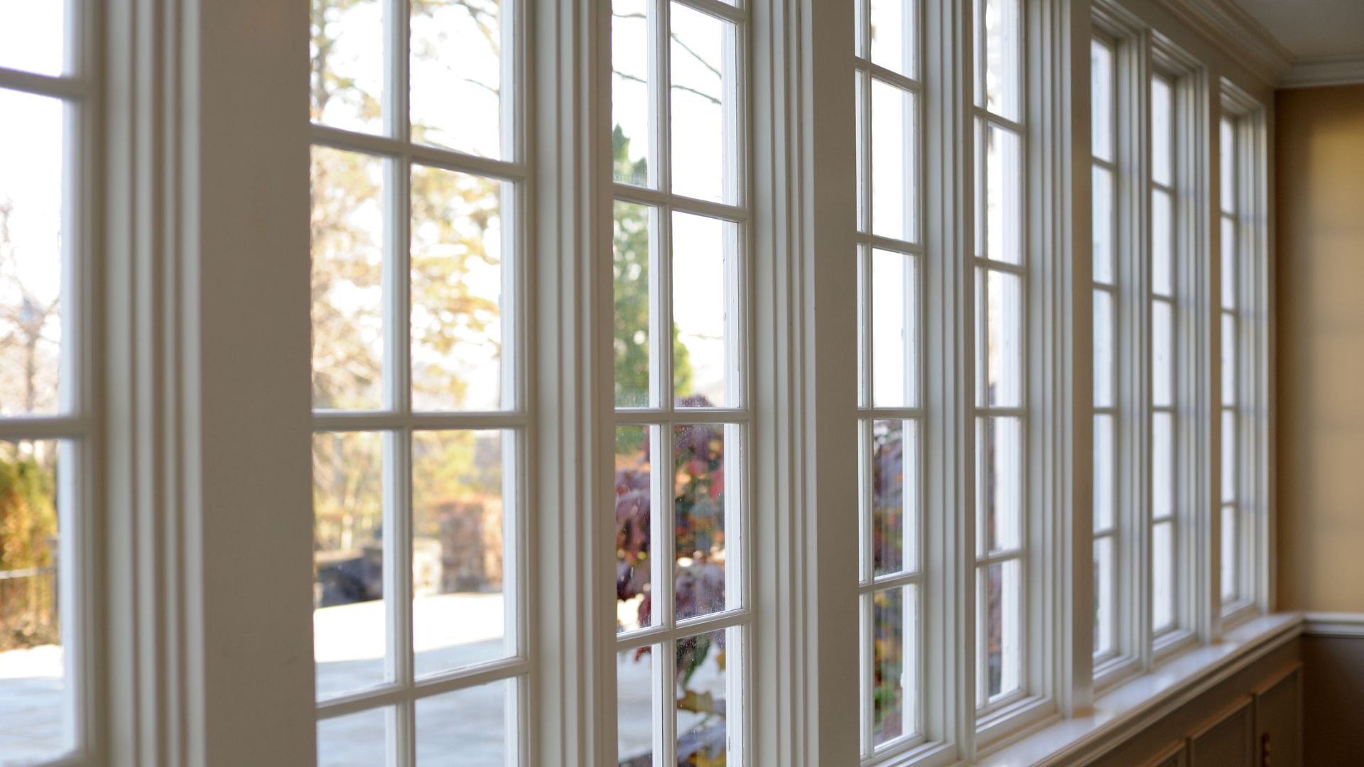 White wooden windows with autumn view, soft natural light streaming in