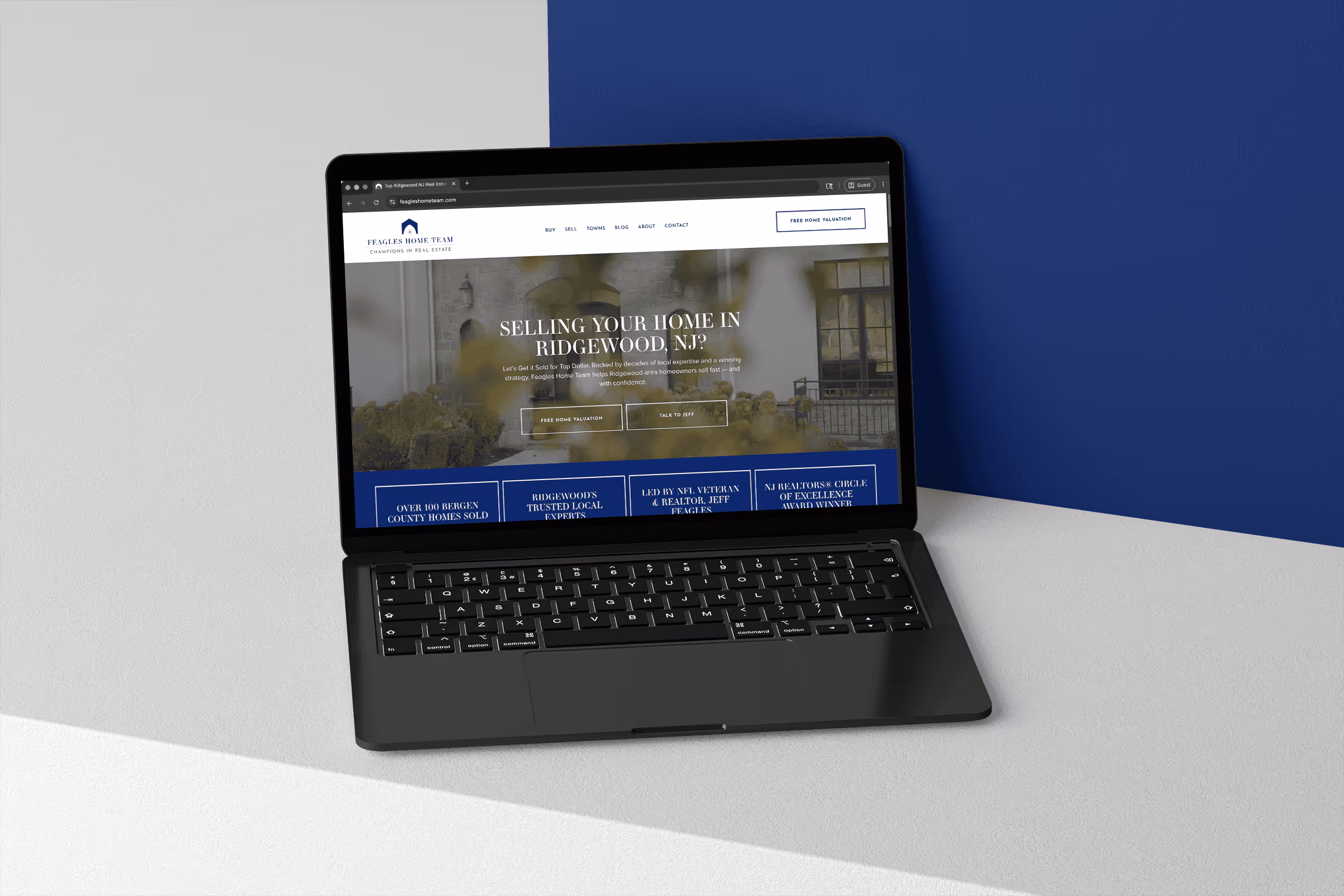 Laptop displaying a real estate website offering home selling services in Ridgewood, NJ with options for free home valuation and talking to an agent.