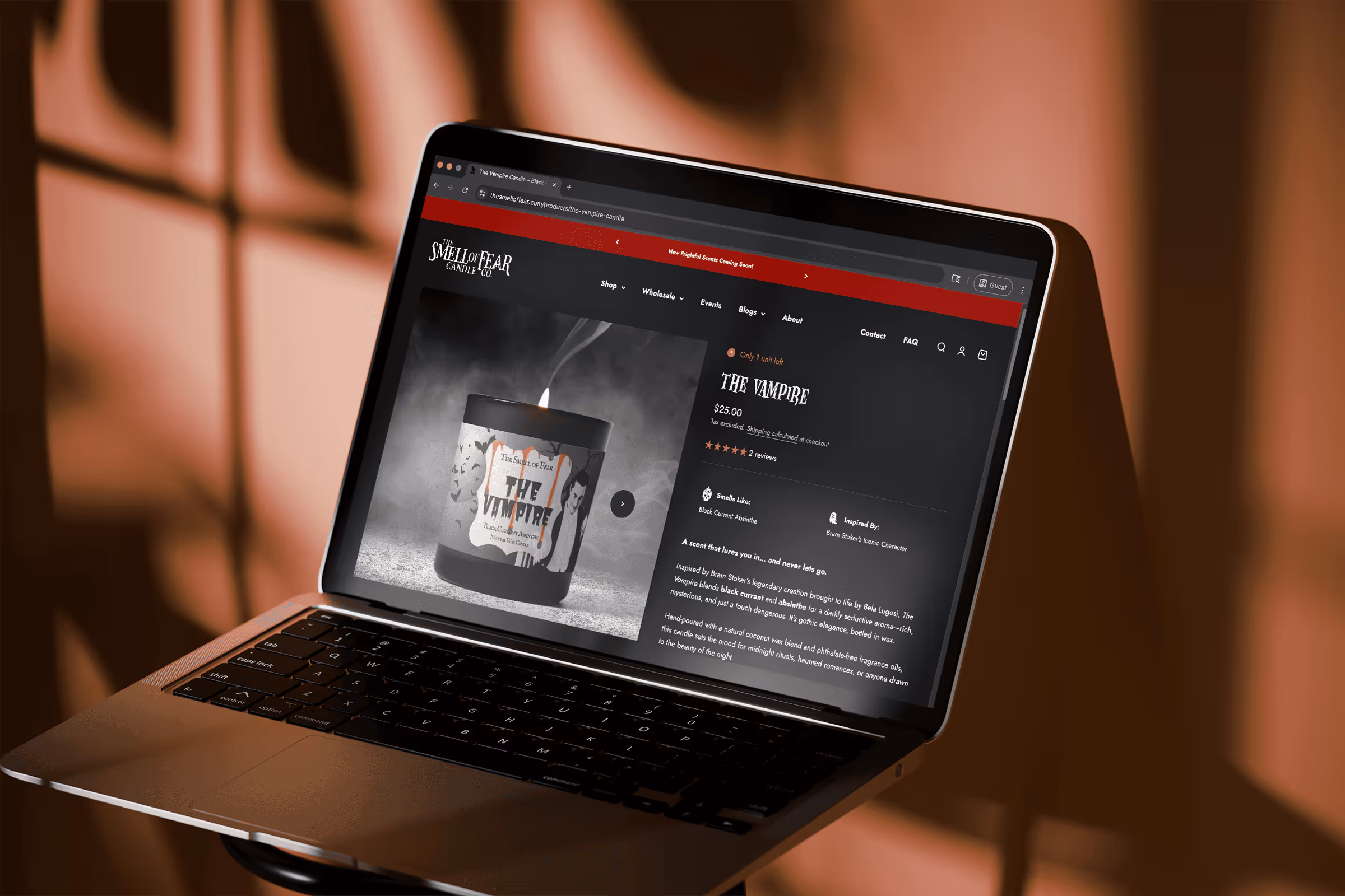 Open laptop displaying a webpage for 'The Vampire' scented candle from The Smell of Fear Candle Co., priced at $25 with product details and a lit candle image.