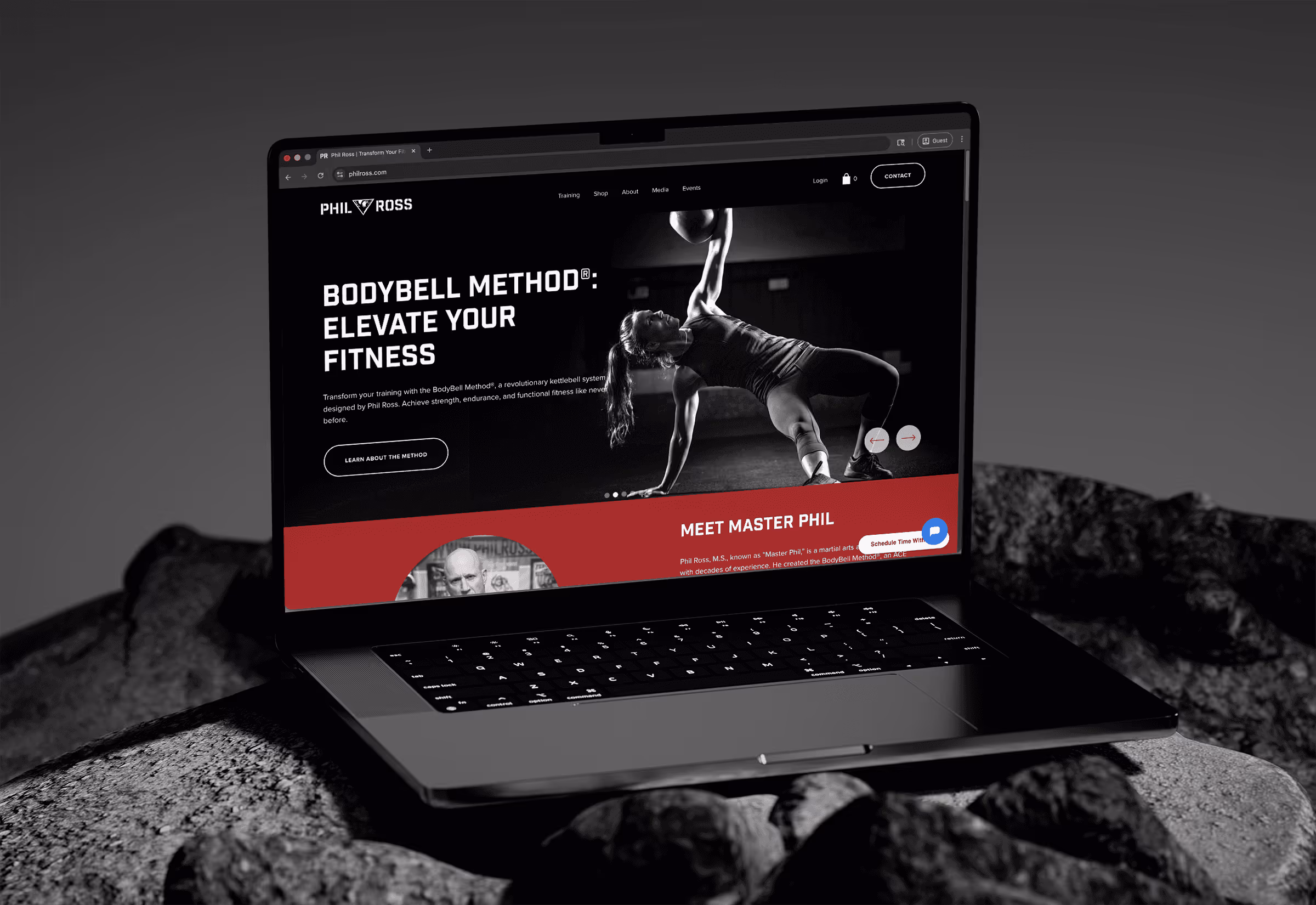Open laptop displaying a fitness website featuring the BodyBell Method and a woman exercising with a kettlebell.