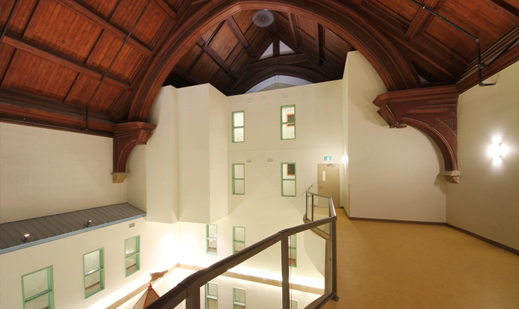 Heritage church interior in Winnipeg converted to housing, new walls built beneath the original timber vault