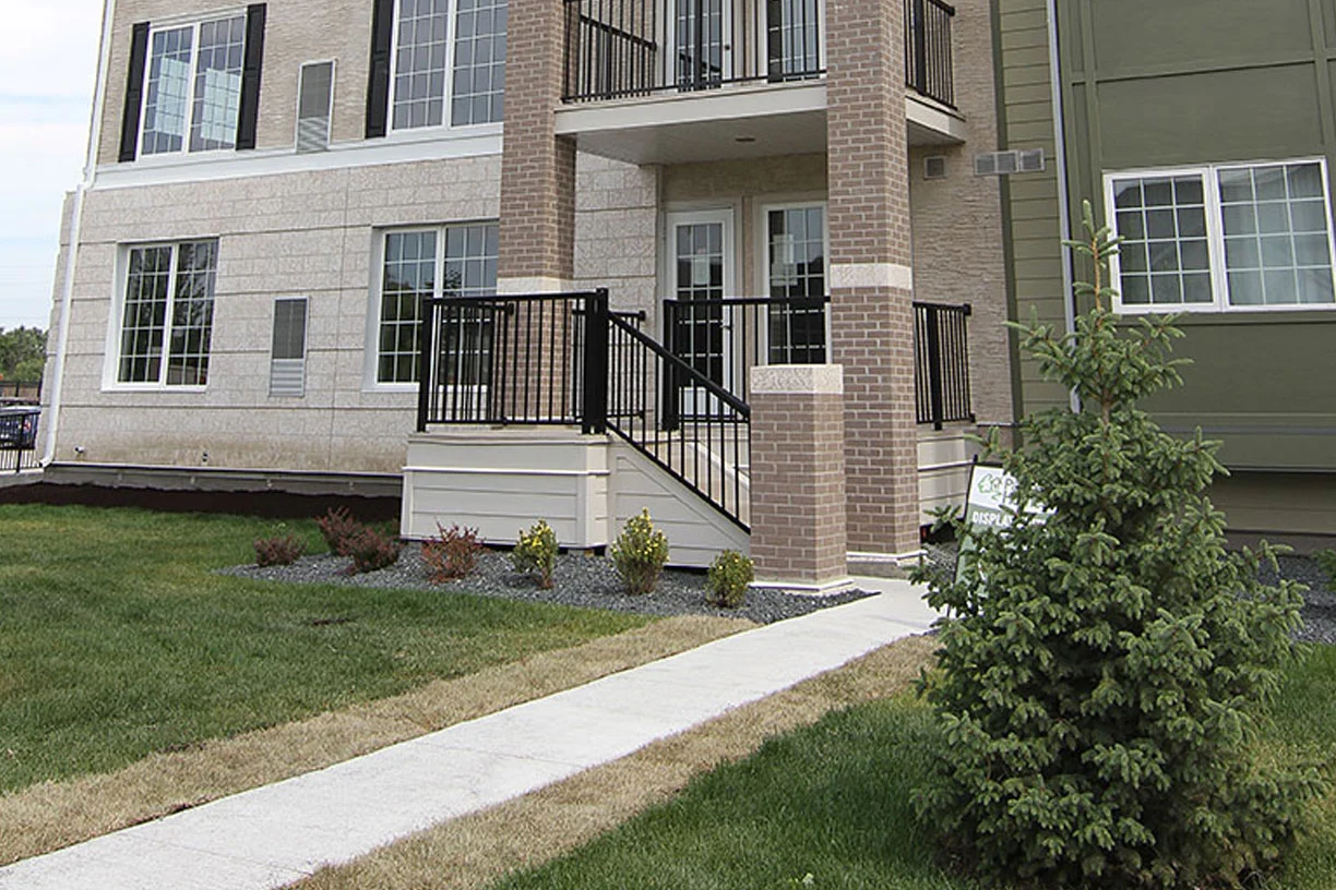 Apartment building entrance in Winnipeg with brick columns and steel stair railings