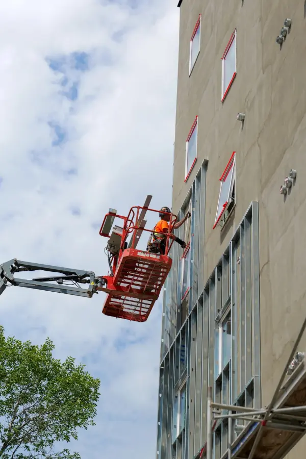 Worker on a boom lift working on the exterior wall at 939 Chancellor Drive in Winnipeg