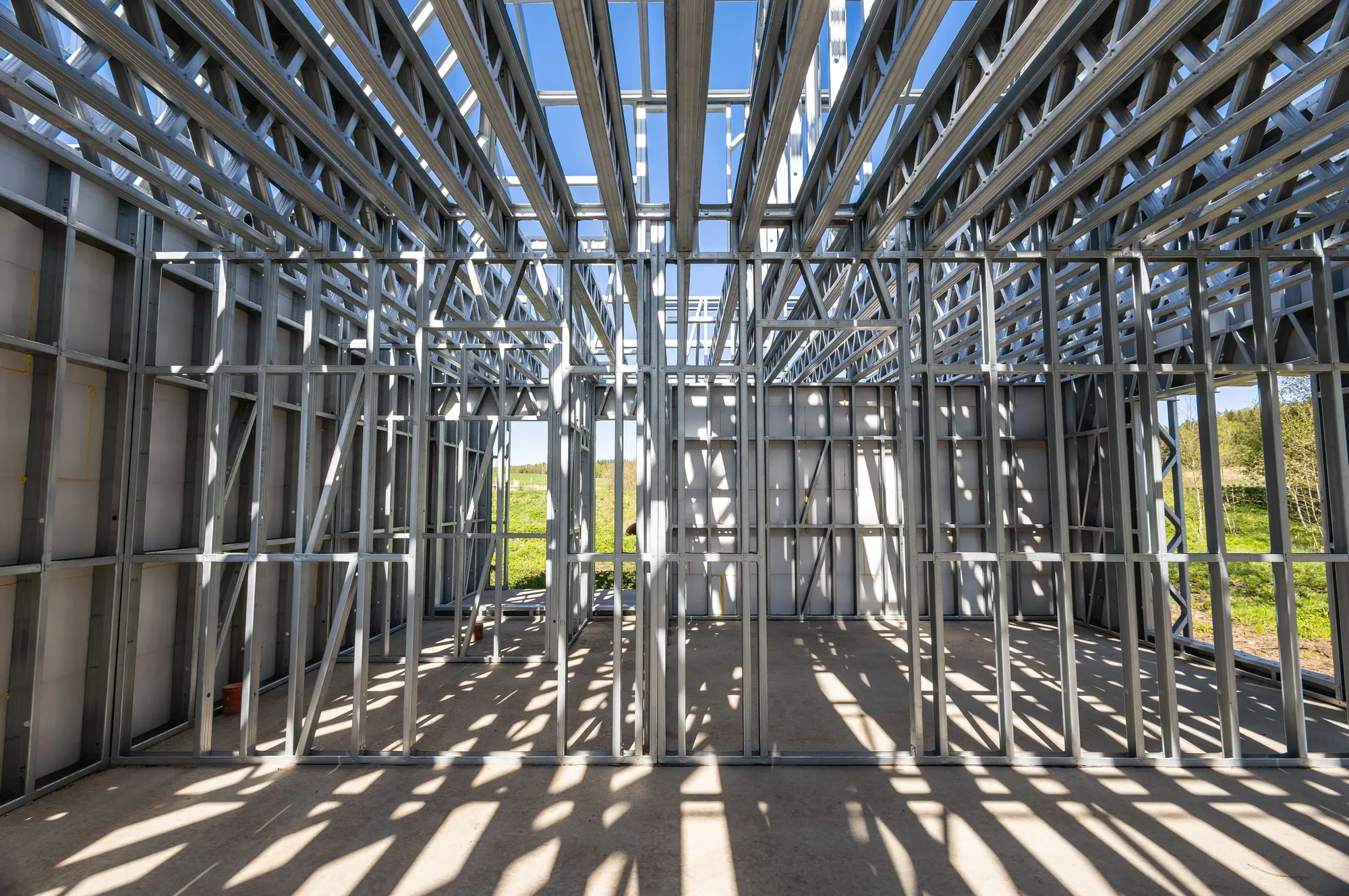 Steel stud framing erected for interior walls and roof trusses on a construction site