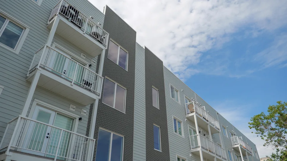 Looking up at the balconies and grey cladding of 333 Wardlaw in Winnipeg