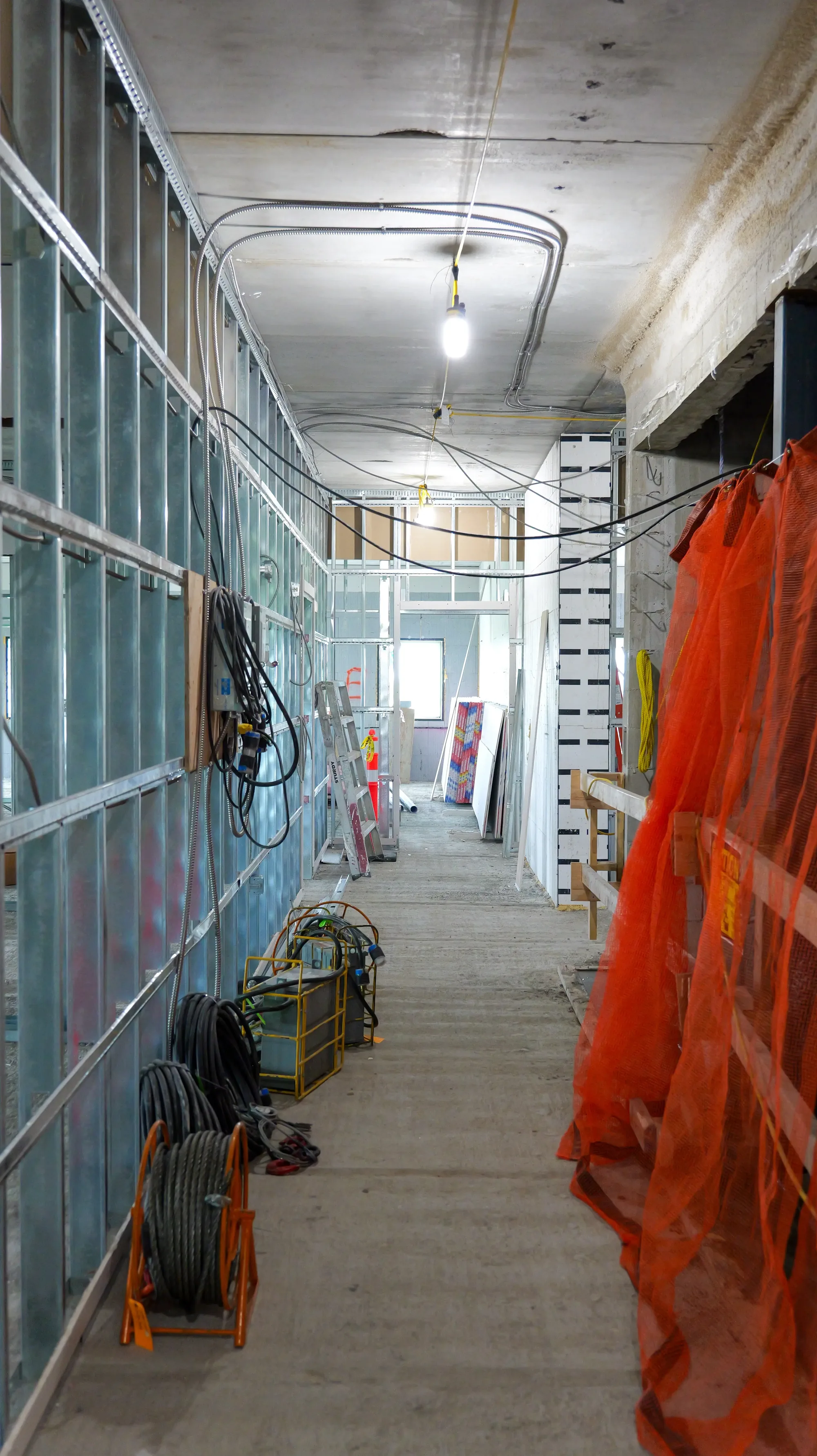Corridor under construction at 939 Chancellor Drive with glazing installed and services roughed in