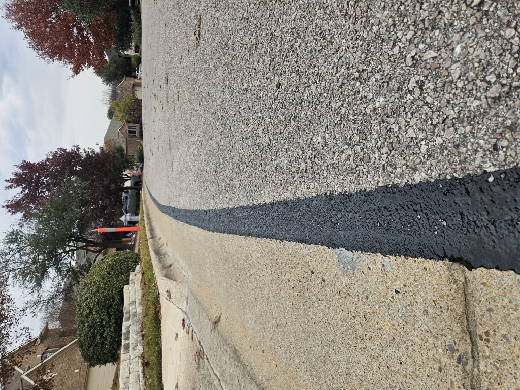 A freshly sealed fiber line on the curbside in austin texas.