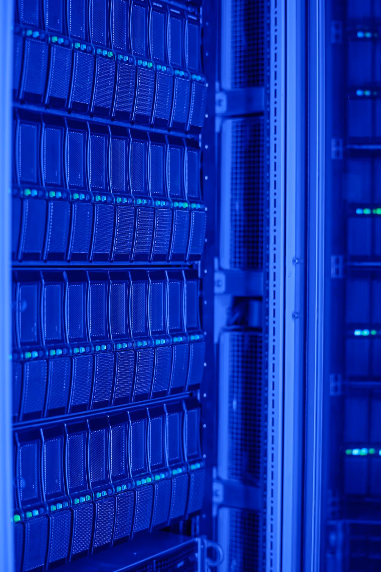 Blue-lit server room with rows of stacked servers and blinking green lights, conveying a high-tech and efficient data processing environment.
