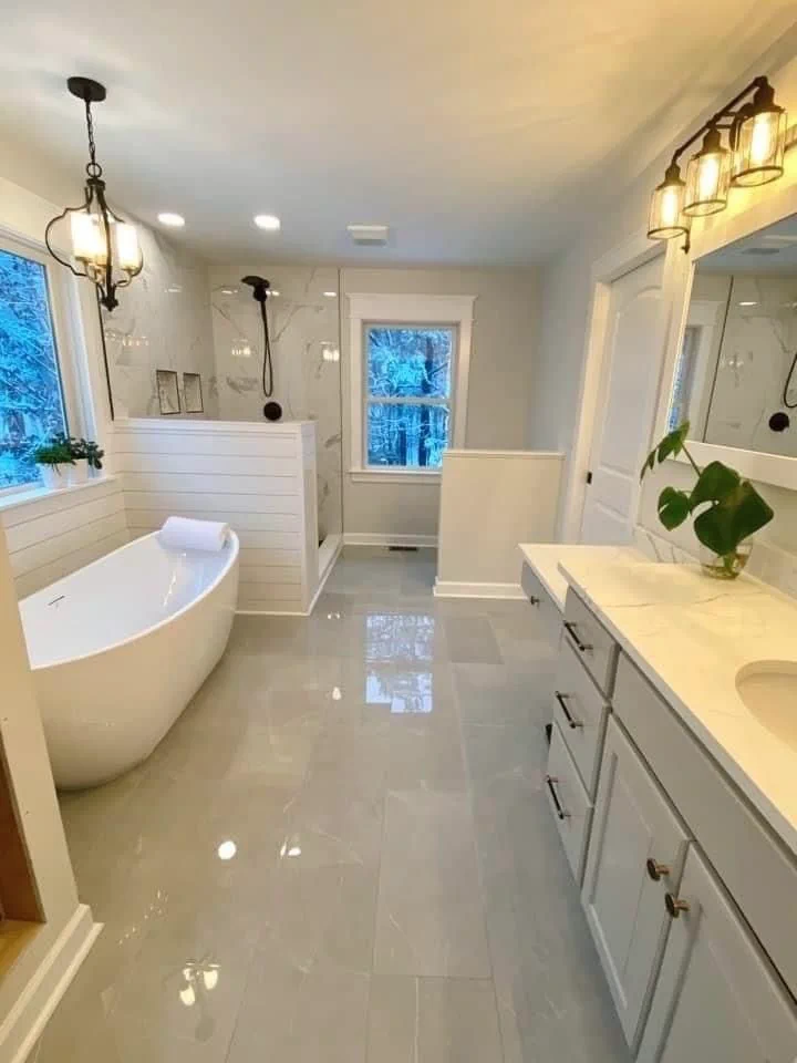 This may contain: a large white bathroom with an oval tub and double sinks