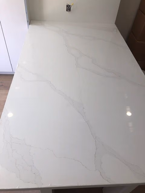 This may contain: a white marble counter top in a kitchen